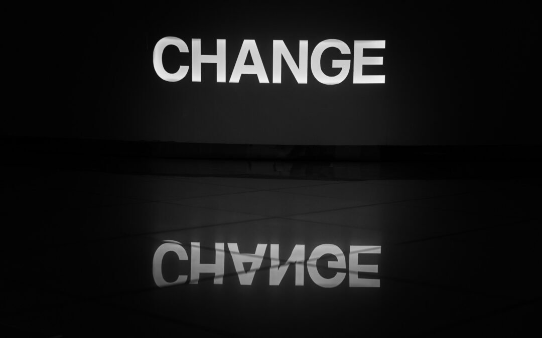 The word "CHANGE" in white capital letters on a black background, with its reflection below.